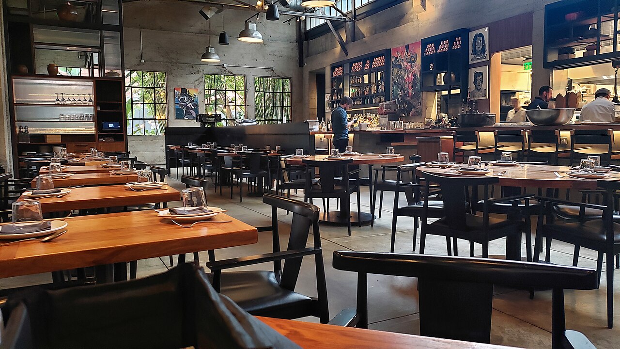 Wnętrze restauracji z nakrytymi stołami i ciepłym oświetleniem