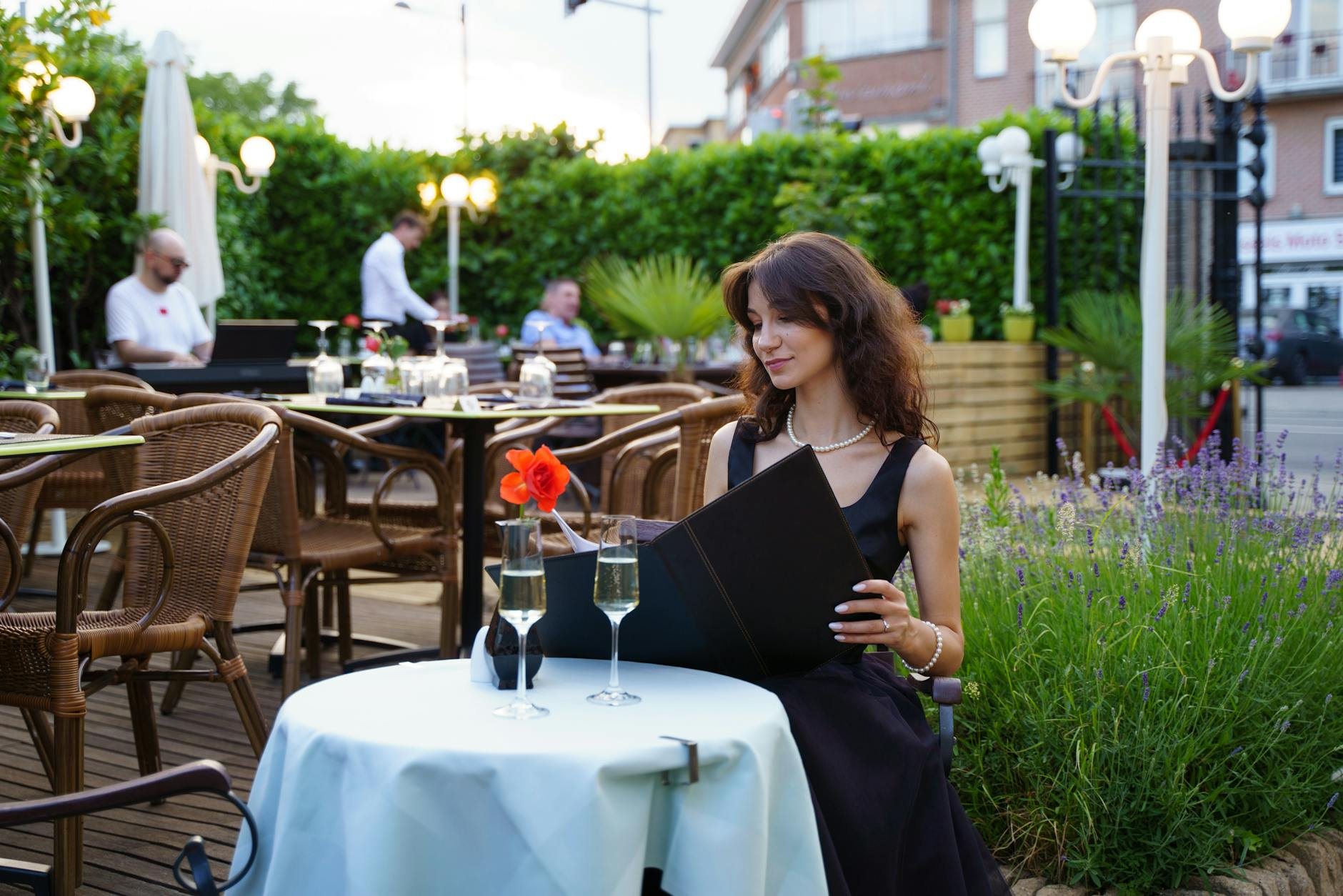 Goście przy stoliku na ogrodowej terasie restauracji